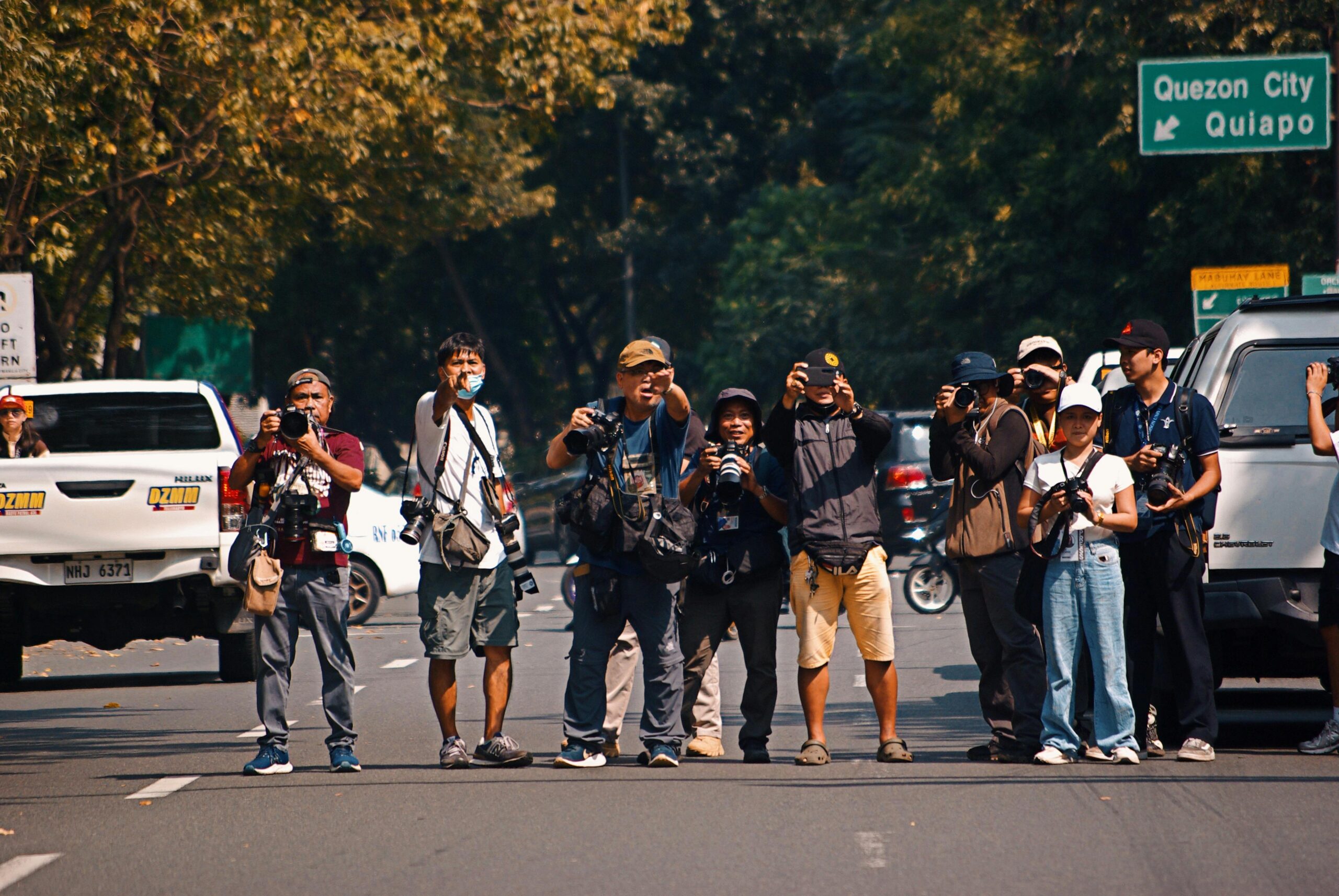 Photographers taking pictures on a busy street in Quezon City, Philippines.